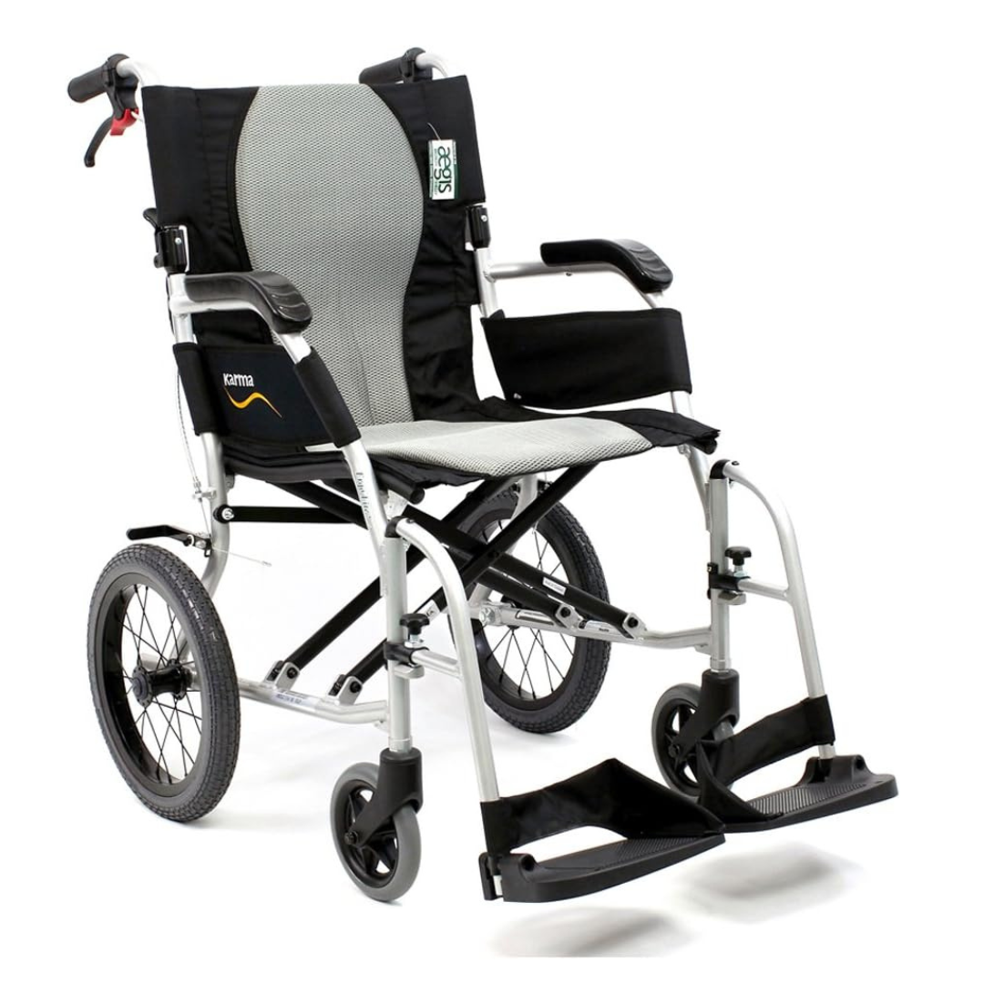 The Karman Ergo Flight Ultra Lightweight Ergonomic Transport Chair features a black and gray seat, foldable design, large rear wheels, smaller front wheels, footrests, red-accented handles, and the Karma brand logo on the backrest for an excellent mobility solution.